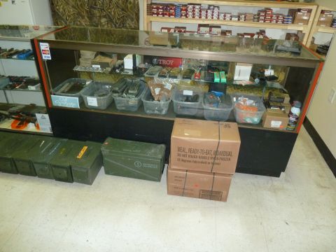 1992 Ford Mustang - Interior view of a store with merchandise displayed in cases and storage containers on the floor.