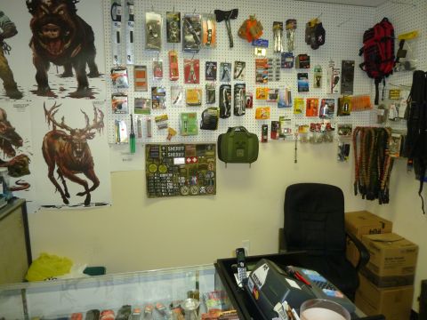 1992 Ford Mustang - A store displays various tools, survival gear, and patches on a pegboard wall, with a desk and merchandise in the foreground.