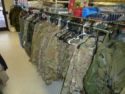 1992 Ford Mustang - A retail display features camouflage uniforms and outdoor equipment, including lanterns and bags.