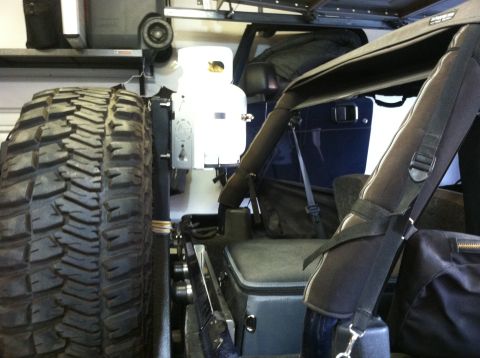 2005 Jeep Wrangler - Interior view of a dark blue Jeep Wrangler, a large spare tire mounted externally.