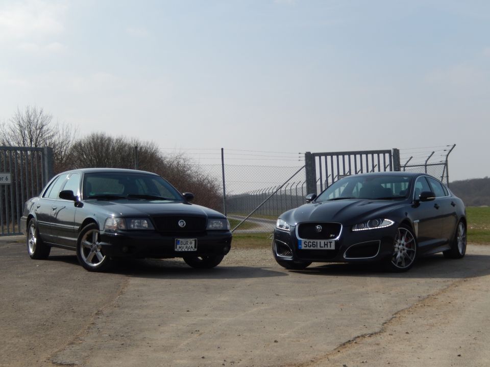 Black 2003 Mercury Marauder parked on gravel, front-left view, with a Jaguar in the background