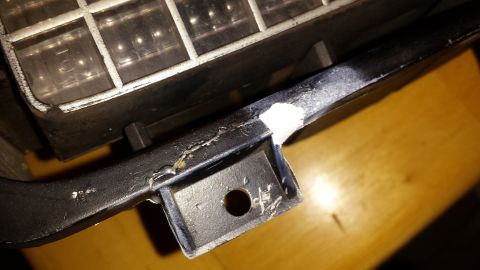 1976 Ford Ranchero - Close-up of a damaged automotive part, possibly a headlight assembly, showing wear and tear.