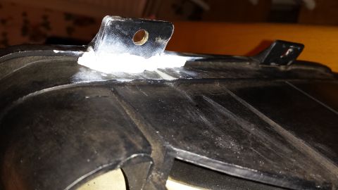 1976 Ford Ranchero - This is a close-up of an automotive part, possibly a headlight housing, showing mounting brackets.