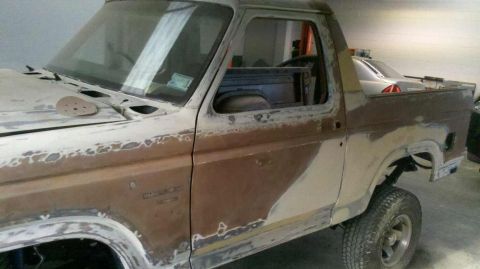 1982 Ford Bronco - This 1982 Ford Bronco is shown in primer, indicating it is in the process of bodywork and repair.