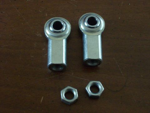 1982 Ford F-100 - Two rod end bearings and two nuts are shown on a wooden table.