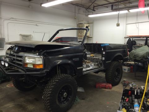 1992 Ford Bronco - This 1992 Ford Bronco is undergoing work in a garage, with its hood open and doors removed.