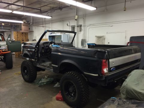 1992 Ford Bronco - This 1992 Ford Bronco is undergoing modifications in a workshop, with its roof removed and lifted suspension.