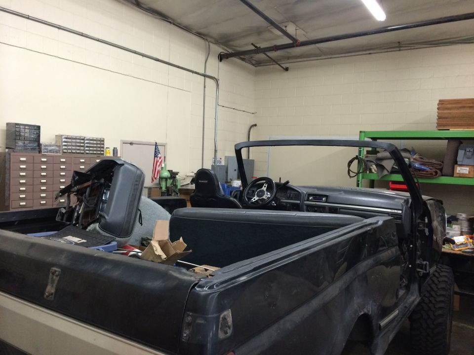 1992 Ford Bronco interior with dashboard, steering wheel, and seats visible. Rear bed is also shown