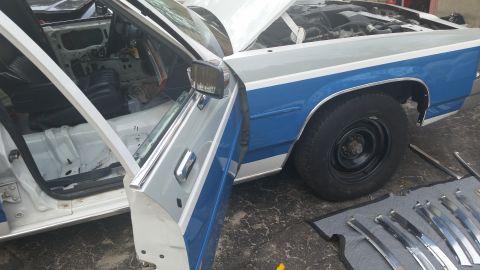 1991 Ford LTD Crown Victoria - A white and blue sedan is shown with its doors and hood open, revealing a disassembled interior and engine bay.