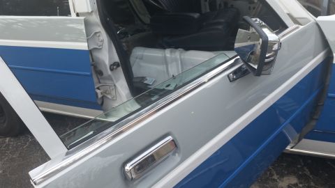 1991 Ford LTD Crown Victoria - Interior view of a car with gray and blue two-tone paint, showing the open driver's door and seat.