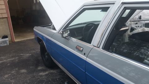 1991 Ford LTD Crown Victoria - A two-tone Ford Crown Victoria sits in a driveway with its hood up.