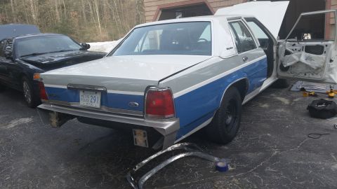 1991 Ford LTD Crown Victoria - A two-tone Ford Crown Victoria is parked outside with its hood and driver's door open, showing interior work in progress.