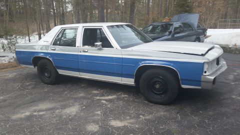 1991 Ford LTD Crown Victoria - A two-tone blue and silver 1991 Ford Crown Victoria LTD sedan is parked outside with its hood up, and another car is visible in the backgro…