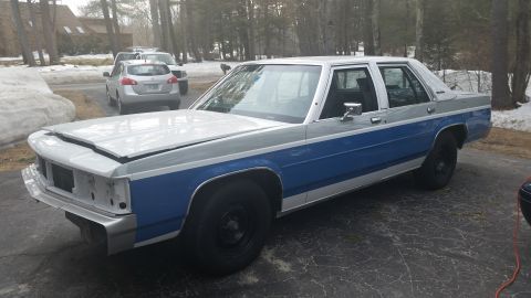 1991 Ford LTD Crown Victoria - This sedan has a two-tone paint scheme and appears to be undergoing some form of maintenance or restoration.