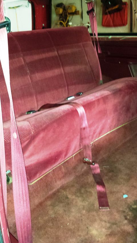 2001 Ford F-150 - The interior of a vehicle shows a maroon velour bench seat with pink seatbelts.