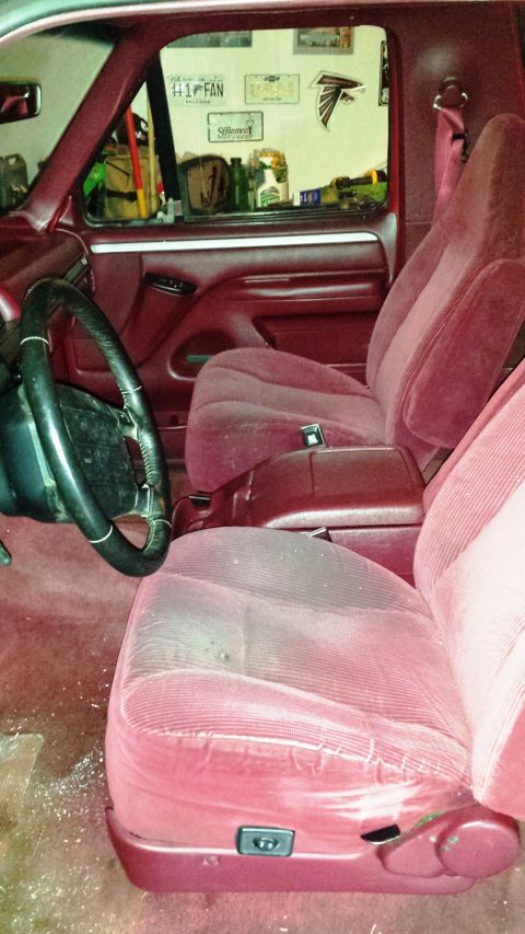 2001 Ford F-150 - Interior view of a red Ford Bronco, showing the seats and dashboard.