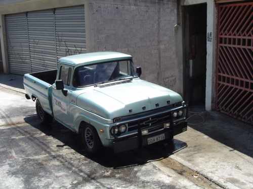 Light blue 1967 Ford F-100 pickup truck, front 3/4 view, parked on a paved surface