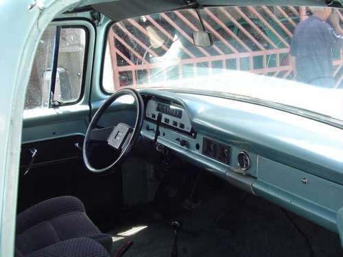 Interior of a light blue 1960s truck, showing dashboard and steering wheel
