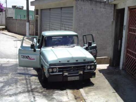 1970 Ford F-100 - A light blue Ford pickup truck is parked on a street with its doors open.