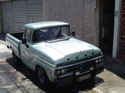 Light blue 1967 Ford F-100 pickup truck with a black grille guard and "TAXI" text on the door
