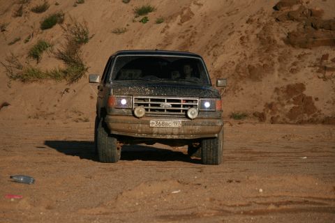 1987 Ford Bronco - This 1987 Ford Bronco is shown head-on, covered in dust, on a sandy track.