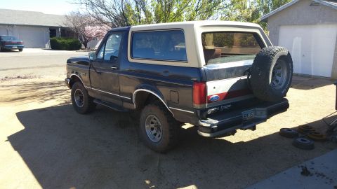 1990 Ford Bronco - Rear view of a 1990 Ford Bronco showing the spare tire and two-tone paint scheme.