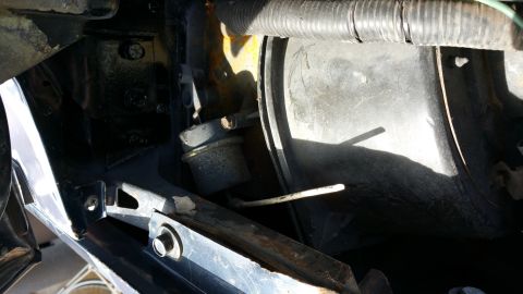 1990 Ford Bronco - Close-up view of engine bay components, including hoses and metal brackets, with signs of wear and tear.