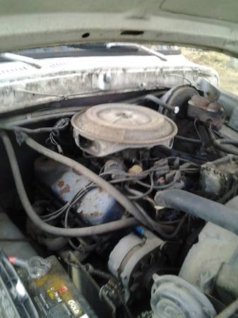 1978 Ford Bronco - The engine compartment of an older vehicle is visible, with various mechanical components.