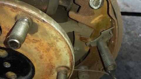 1978 Ford Bronco - Close-up of a vehicle's brake drum and shoes, showing signs of wear and rust.