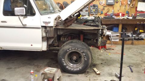 1978 Ford Bronco - This 1978 Ford Bronco is in a garage with its hood up and front fender removed, showing the engine and suspension components.