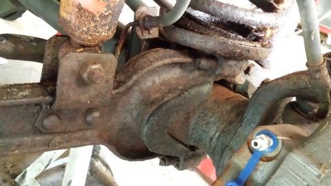 1978 Ford Bronco - Close-up view of heavily rusted rear axle and suspension parts, likely from an older vehicle.