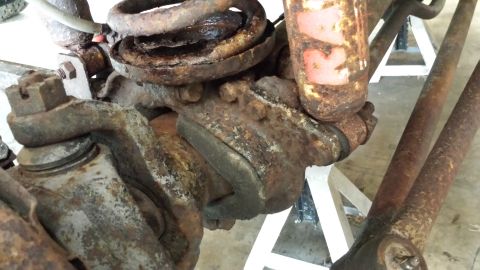 1978 Ford Bronco - Heavily rusted suspension parts are visible, supported by jack stands.