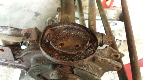 1978 Ford Bronco - Close-up view of a heavily corroded front axle component, showing significant rust and wear.