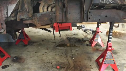 1978 Ford Bronco - Underbody of a vehicle on jack stands, showing the frame and exhaust system.