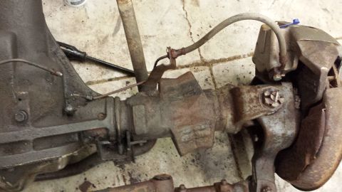 1978 Ford Bronco - This is a close-up view of a used rear axle assembly, showing brake lines and rusty components.