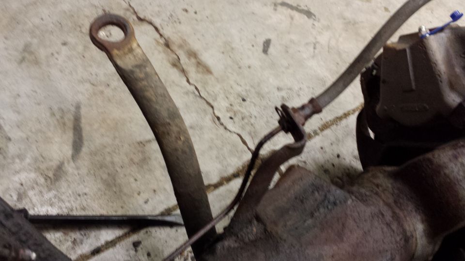 Rusted metal components on a concrete floor with a SuperMotors.net watermark