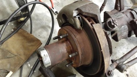 1978 Ford Bronco - This photo shows a close-up of a rusty vehicle brake assembly, including the rotor, caliper, and hub.