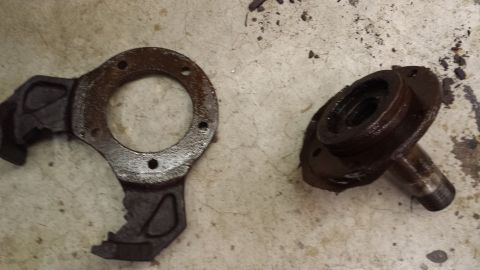 1978 Ford Bronco - These old, greasy vehicle components are shown on a stained concrete surface.