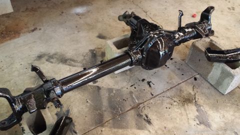 1978 Ford Bronco - A freshly painted rear axle assembly rests on concrete blocks, ready for installation.