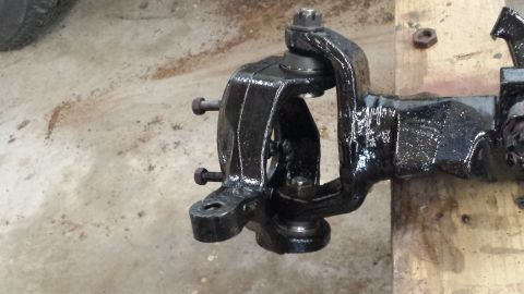 1978 Ford Bronco - Close-up of a vehicle's suspension knuckle and ball joint assembly, painted black.