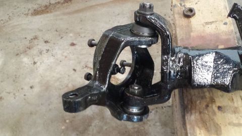 1978 Ford Bronco - This is a close-up view of a vehicle's suspension component, likely a knuckle or spindle, showing its intricate metalwork and hardware.