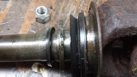 1978 Ford Bronco - Close-up of a greasy automotive part, possibly a hub or axle component, with a nut in the background.