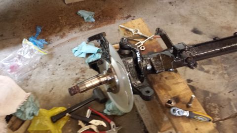 1978 Ford Bronco - Close-up of a vehicle's front axle assembly, showing brake components and suspension parts.