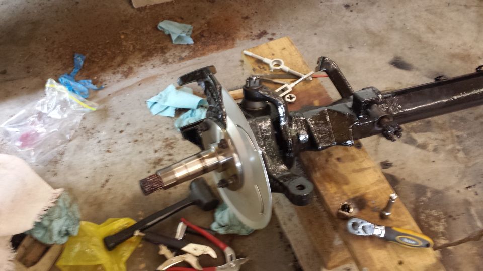 Vehicle front axle assembly with brake rotor and suspension components on wooden blocks