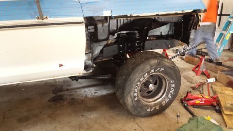 1978 Ford Bronco - This 1978 Ford Bronco is undergoing work, showing its frame and suspension system with a large tire mounted.