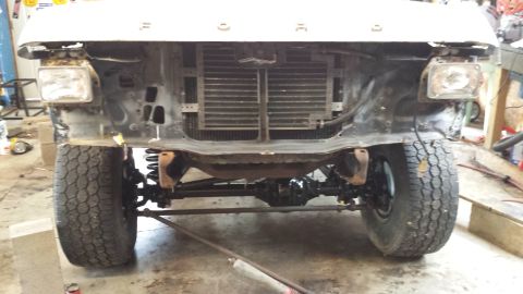 1978 Ford Bronco - The front end of a Ford truck is shown with the grille and headlights removed, revealing the engine bay components.