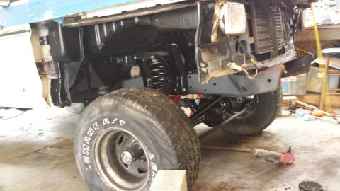 1978 Ford Bronco - The front suspension and wheel of a 1978 Ford Bronco are visible, with parts removed for maintenance.