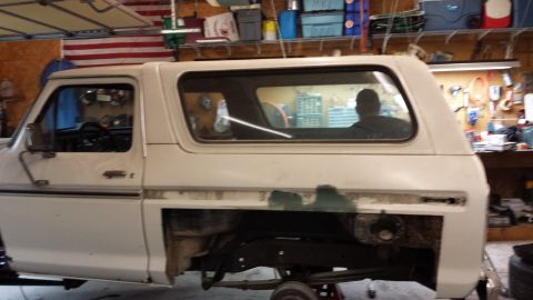 1978 Ford Bronco - This 1978 Ford Bronco is in a garage, showing its side profile during what appears to be a restoration project.
