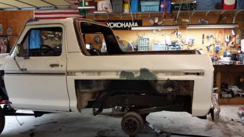 1978 Ford Bronco - Side view of a 1978 Ford Bronco undergoing restoration in a garage setting.