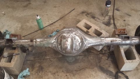 1978 Ford Bronco - A rear axle assembly, likely from a classic vehicle, is shown resting on cinder blocks in a workshop setting.